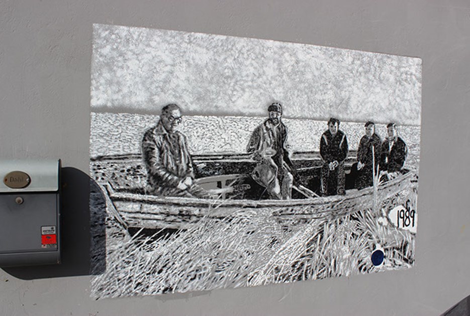 Gavlmalerierne i Åsted. Denne viser mænd i en båd.